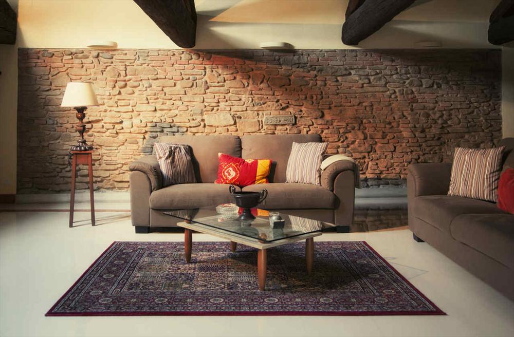 comfortable looking grey couch in a brick wall living room